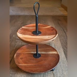 Two tier wooden serving stand with black metal handle.